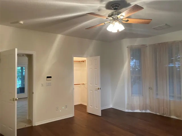 a view of a livingroom with a fan a ceiling fan and hardwood floor