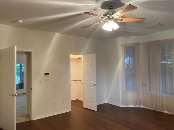 a view of a livingroom with a fan a ceiling fan and hardwood floor
