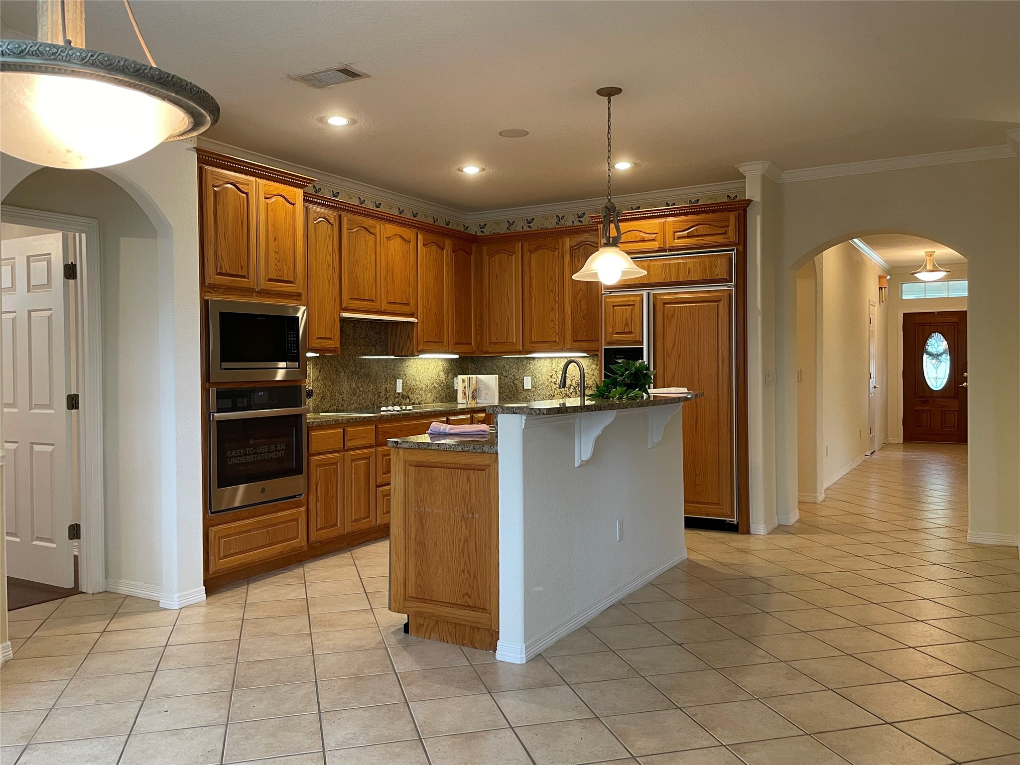 120 Brazos Drive Georgetown, TX 78628 - Photo 18 of 33 a kitchen with kitchen island granite countertop a refrigerator and a stove top oven
