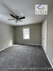 an empty room with a ceiling fan and window