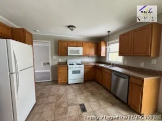 a kitchen with stainless steel appliances granite countertop a refrigerator sink and stove