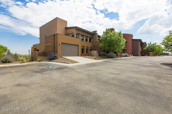 a view of a white building among the ocean with lawn chairs