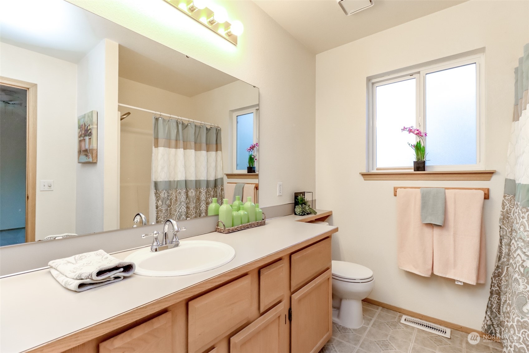 4566 Beckonridge Loop Southeast Lacey, WA 98513 - Photo 27 of 37 a bathroom with a granite countertop sink mirror and a window