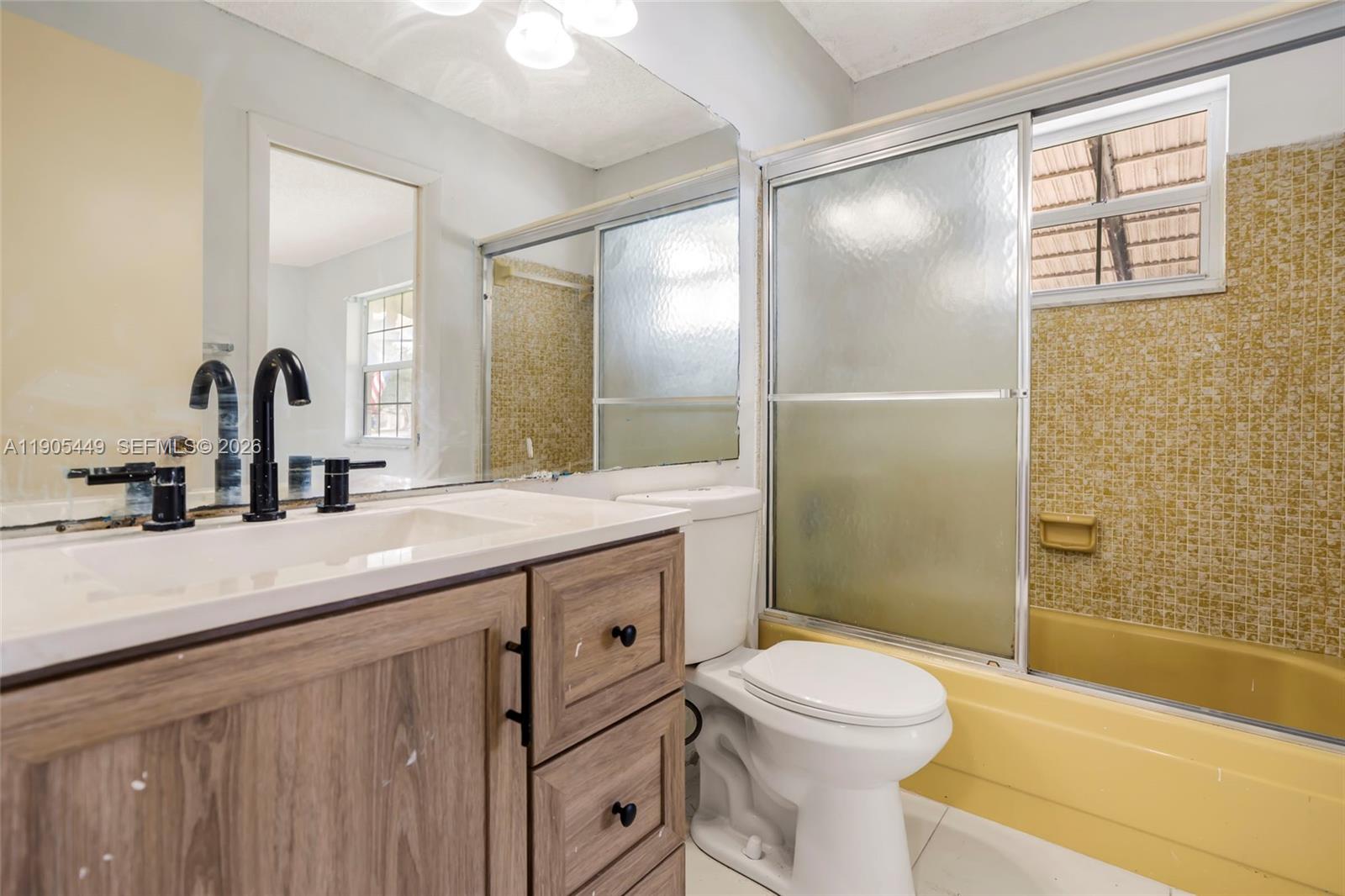 1005 Southwest 18th Street Boynton Beach, FL 33426 - Photo 20 of 44 a bathroom with a sink a toilet and shower