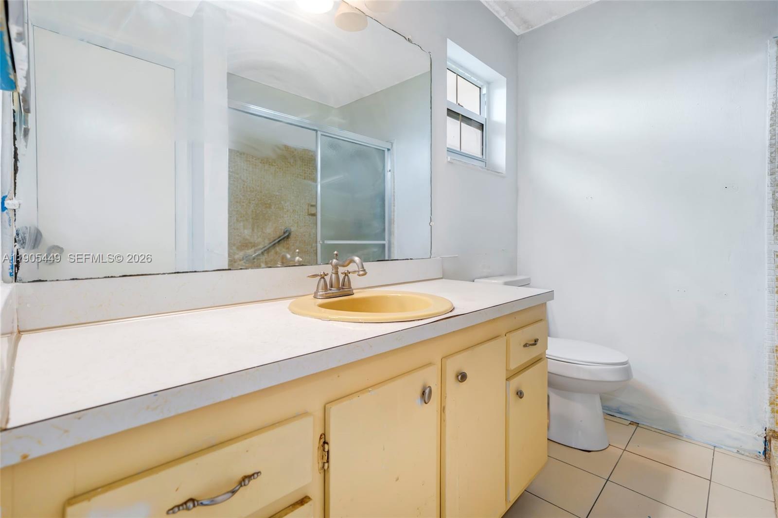 1005 Southwest 18th Street Boynton Beach, FL 33426 - Photo 26 of 44 a bathroom with a granite countertop sink a toilet and a mirror