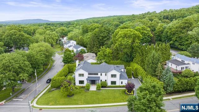 an aerial view of residential houses with outdoor space and trees