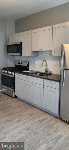 a kitchen with granite countertop a sink and cabinets
