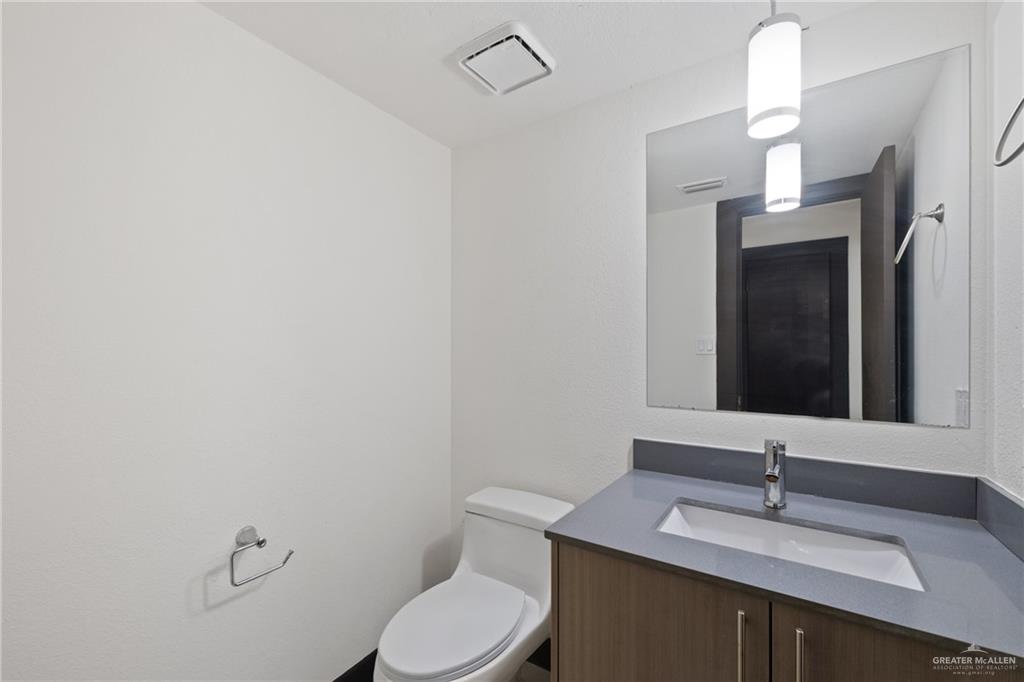 2018 Sabinal Street Mission, TX 78572 - Photo 14 of 20 a bathroom with a sink vanity mirror and toilet