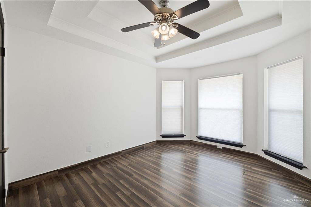 2018 Sabinal Street Mission, TX 78572 - Photo 17 of 20 an empty room with wooden floor chandelier fan and windows