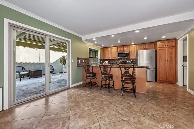 a view of a kitchen with kitchen island granite countertop dining table and stainless steel appliances