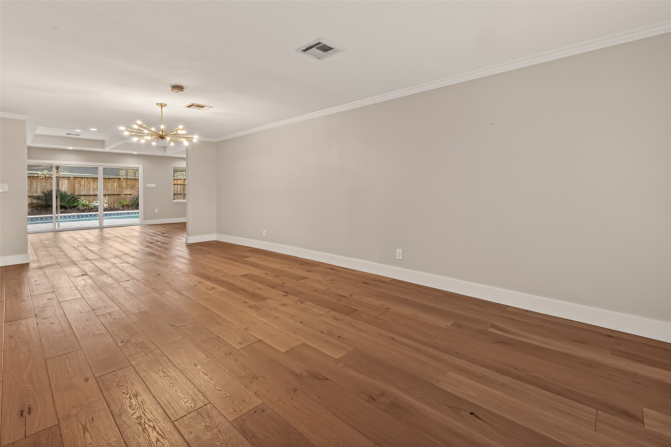 5310 Spellman Road Houston, TX 77096 - Photo 14 of 48 an empty room with wooden floor and chandelier
