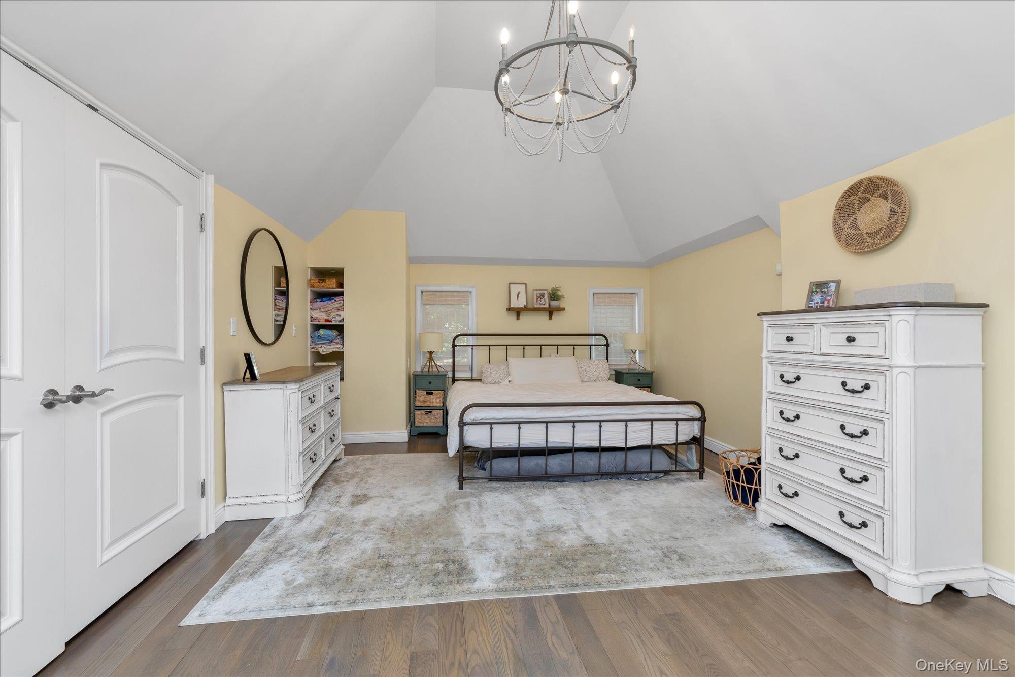 80 Skunks Misery Road Locust Valley, NY 11560 - Photo 17 of 25 a spacious bedroom with a bed and a chandelier