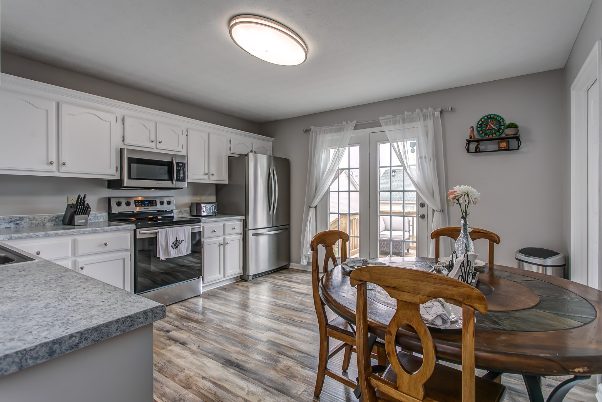 332 Bandera Lane Springfield, TN 37172 - Photo 10 of 22 a kitchen with stainless steel appliances granite countertop a kitchen island hardwood floor sink stove dining table and chairs