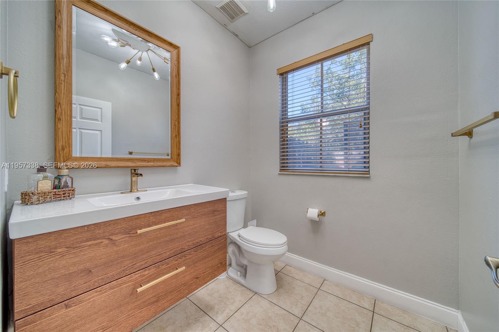 13771 Southwest 274th Terrace Homestead, FL 33032 - Photo 12 of 35 a bathroom with a toilet sink and mirror
