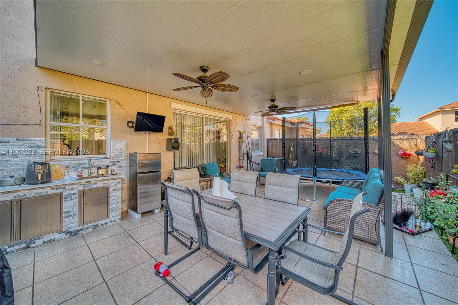 13771 Southwest 274th Terrace Homestead, FL 33032 - Photo 25 of 35 a outdoor space with lots of tables a chair and a fireplace