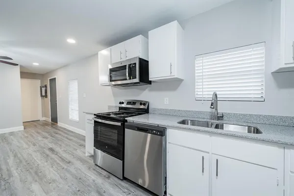 a kitchen with stainless steel appliances granite countertop a sink and a stove top oven