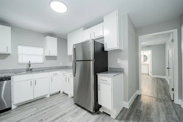 a kitchen with a refrigerator sink and cabinets
