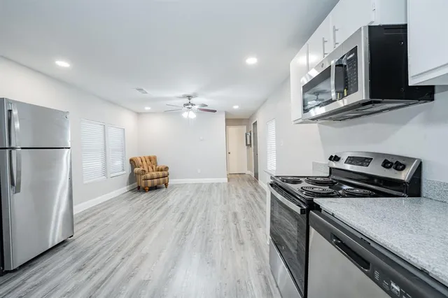 a kitchen with a refrigerator and a stove top oven