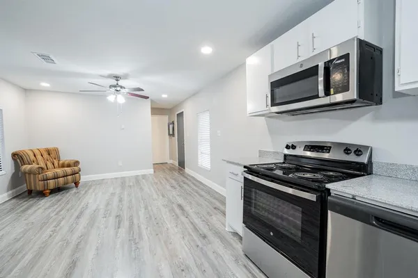a kitchen with granite countertop a stove and a microwave