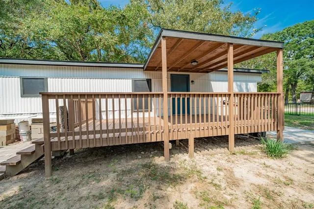 a view of a backyard with a small deck and a garden