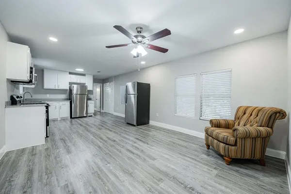 a living room with furniture and kitchen view