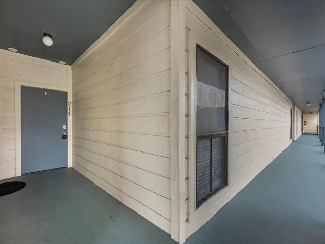 a view of an empty room with a fireplace and a window