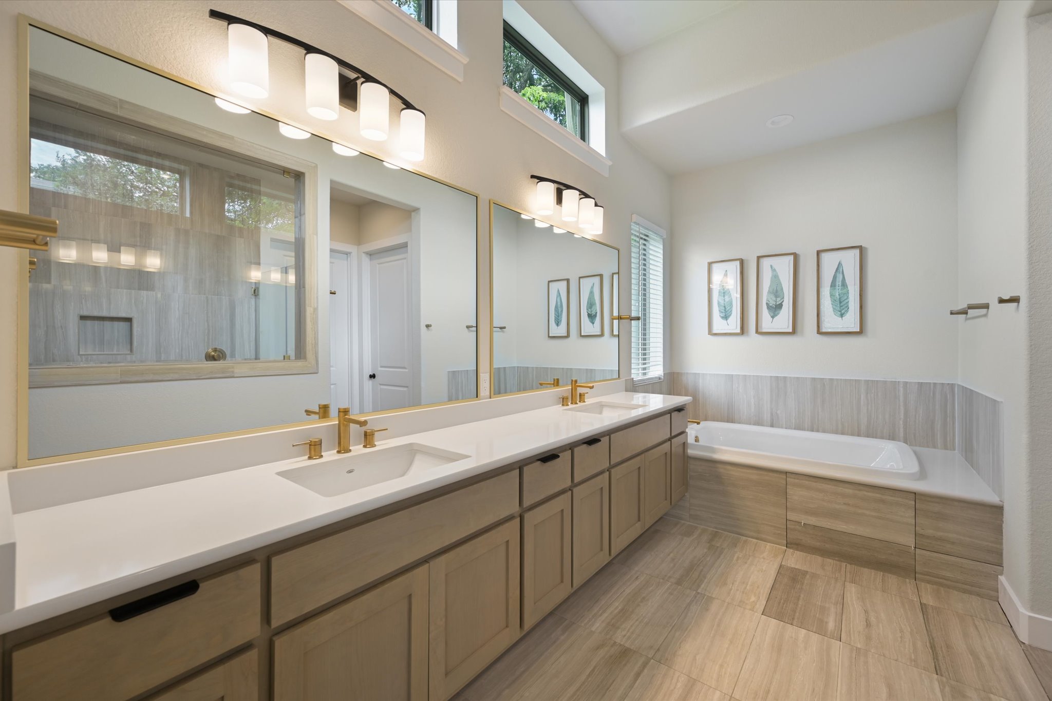 913 Presa Arriba Road Austin, TX 78733 - Photo 18 of 30 Well-lit primary bath features a spacious double vanity and built-in soaking tub, perfect for unwinding.