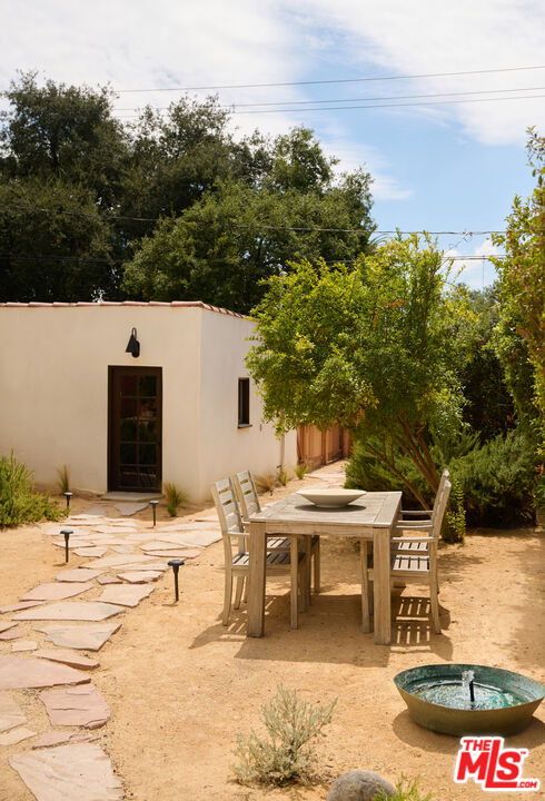 1764 East Orange Grove Boulevard Pasadena, CA 91104 - Photo 28 of 29 a swimming pool with outdoor seating and covered with trees in the background