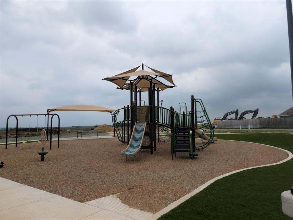 564 Rancho Del Cielo Loop Jarrell, TX 76537 - Photo 9 of 14 Children's playground with swings and slides, ideal for community enjoyment.