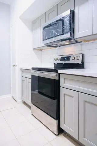 a stove top oven sitting inside of a kitchen