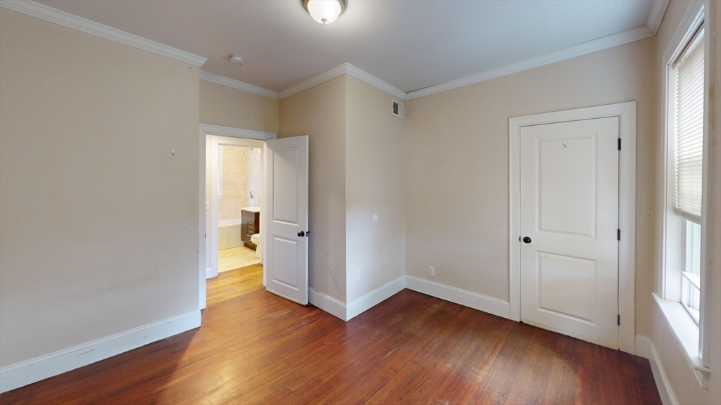 47 Iffley Road, Unit 3 Boston, MA 02130 - Photo 6 of 10 a view of empty room with wooden floor and window