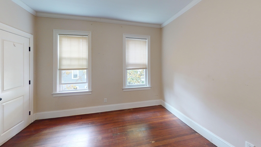 47 Iffley Road, Unit 3 Boston, MA 02130 - Photo 7 of 10 an empty room with wooden floor and windows