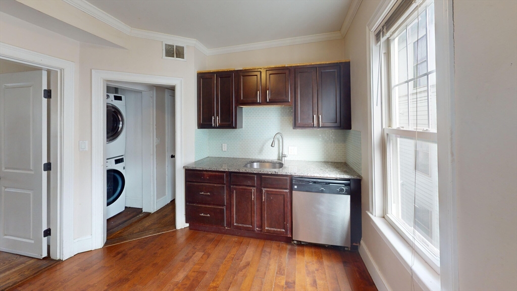 47 Iffley Road, Unit 3 Boston, MA 02130 - Photo 8 of 10 a kitchen with stainless steel appliances granite countertop wooden cabinets a stove a sink and a large window