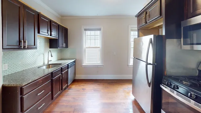 a kitchen with stainless steel appliances granite countertop a refrigerator stove and sink