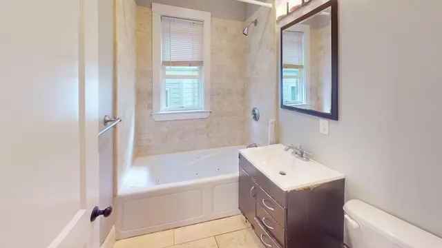 a bathroom with a tub sink and mirror