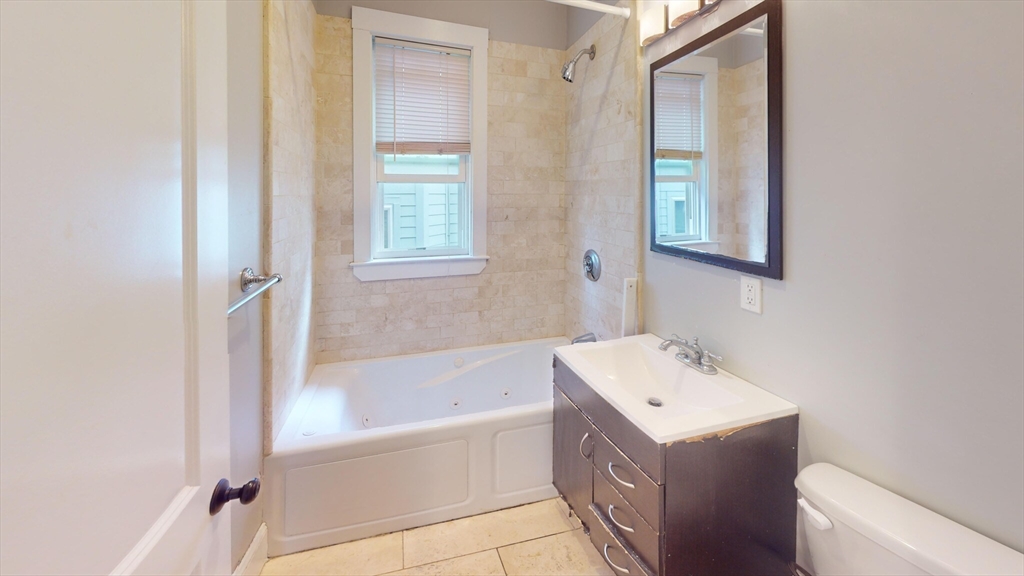 47 Iffley Road, Unit 3 Boston, MA 02130 - Photo 10 of 10 a bathroom with a tub sink and mirror