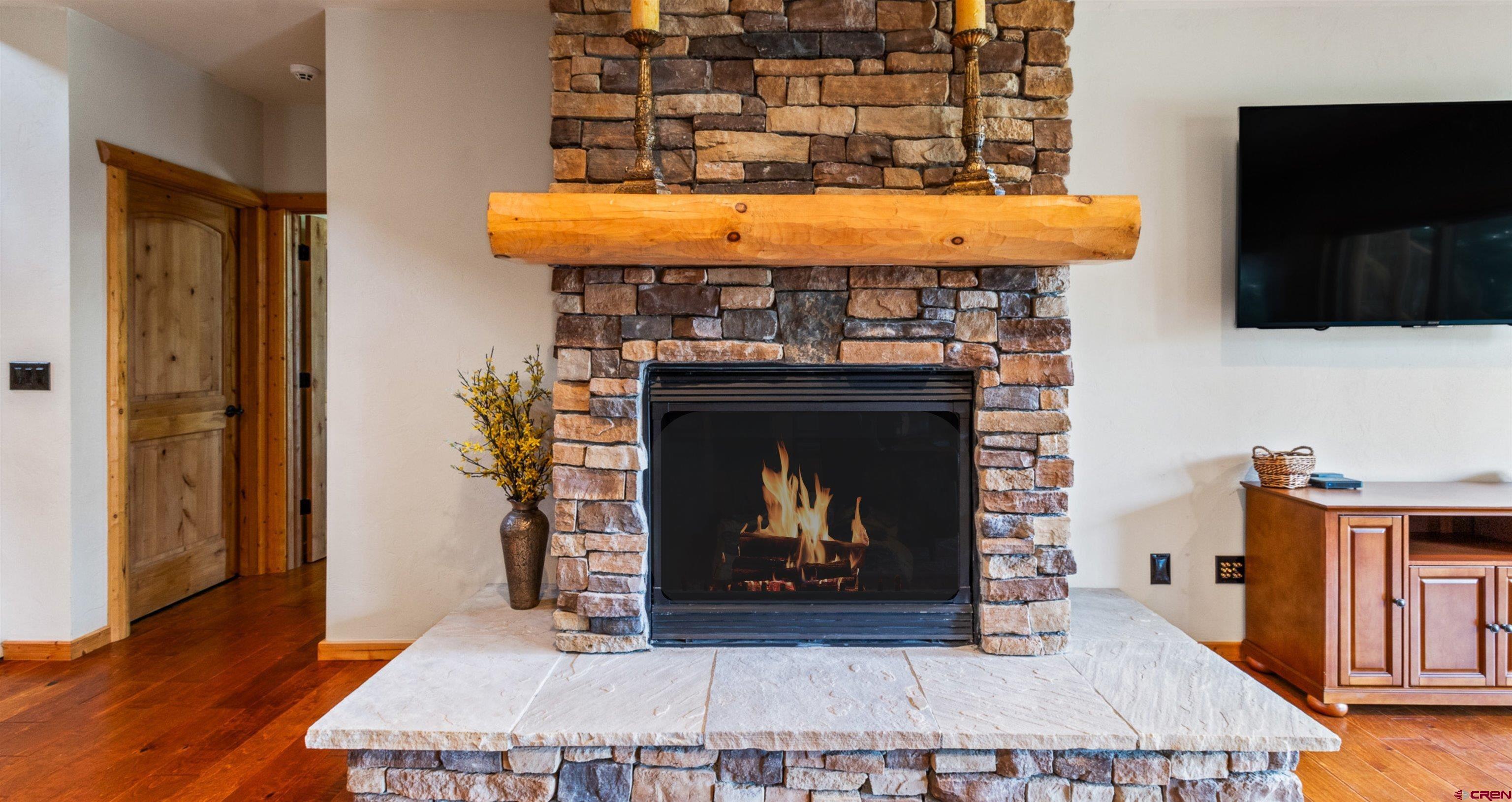 640 Clearview Road Durango, CO 81301 - Photo 28 of 40 a living room with a fireplace a flat screen tv and a table