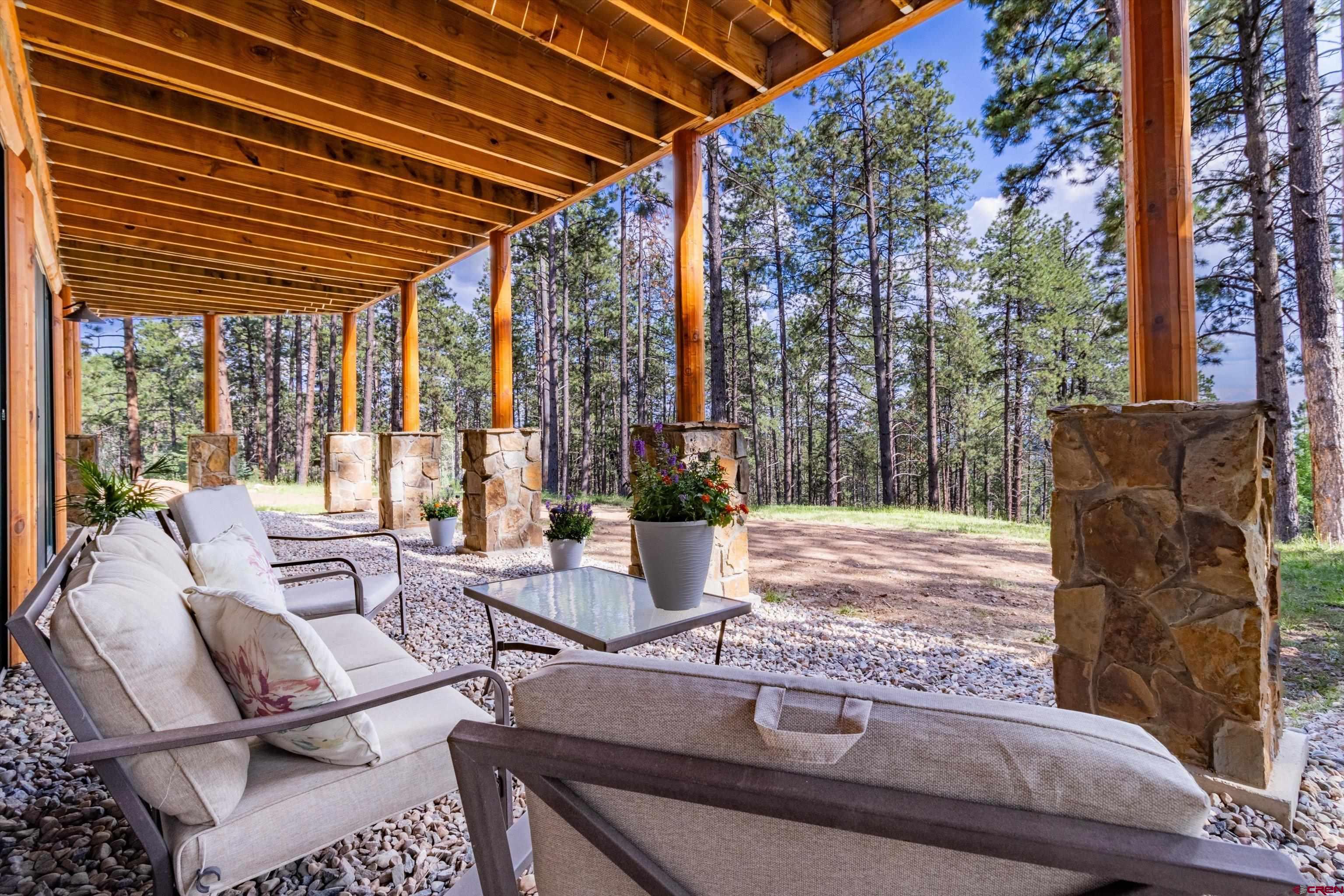 640 Clearview Road Durango, CO 81301 - Photo 32 of 40 a view of a patio with table and chairs potted plants and large tree