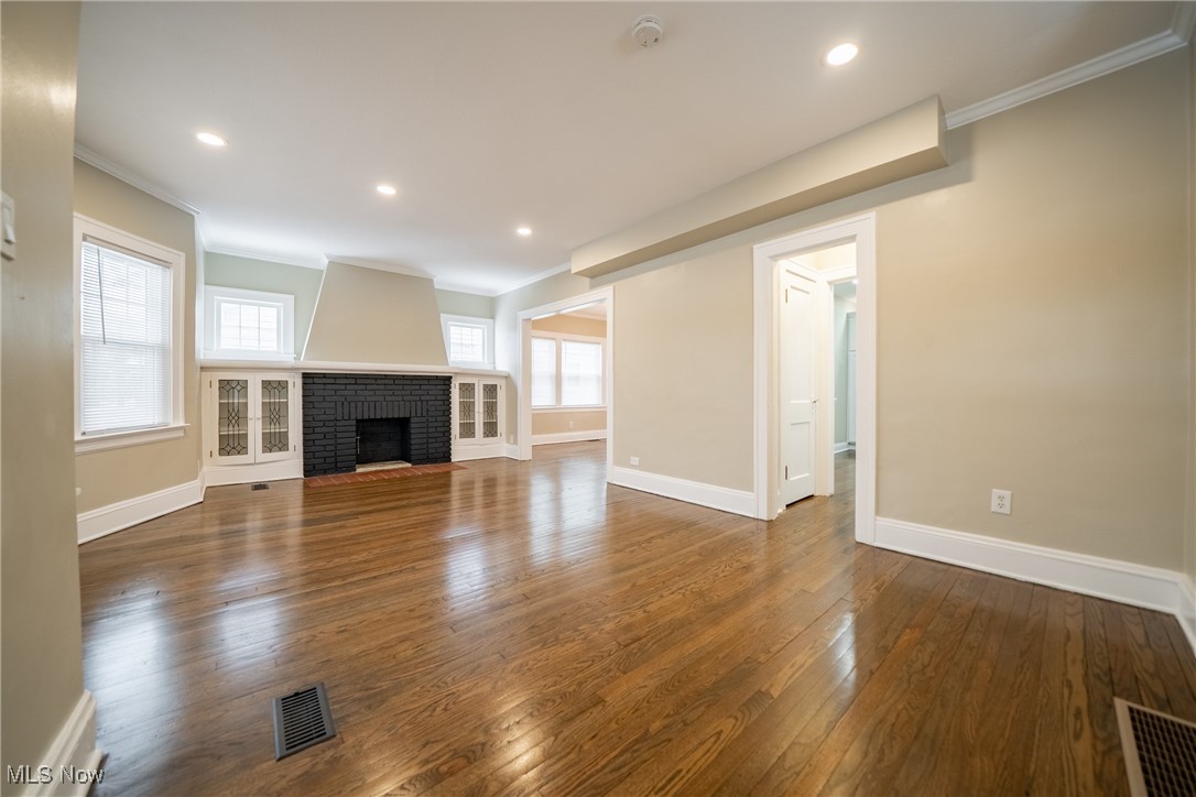 3816 Summit Park Road Cleveland Heights, OH 44121 - Photo 3 of 35 Unfurnished living room with ornamental molding, a brick fireplace, dark wood finished floors, and recessed lighting