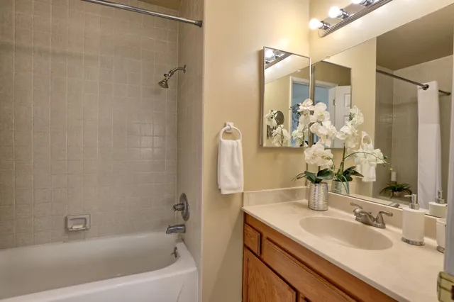 a bathroom with a granite countertop sink a mirror a shower and a bathtub