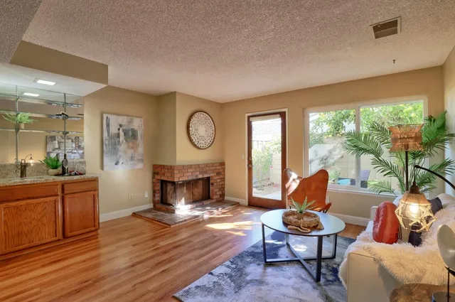 a living room with furniture a fireplace and a large window