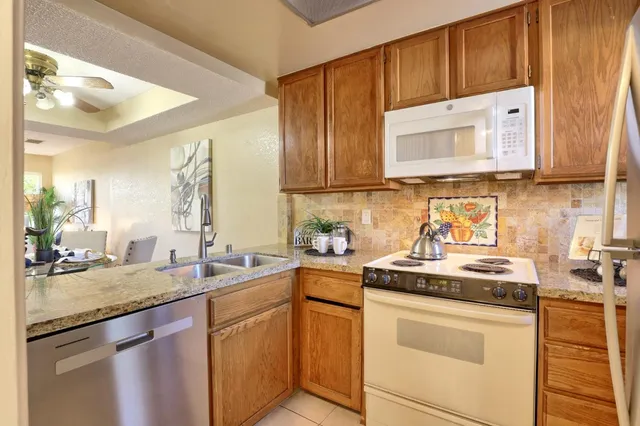 a kitchen with stainless steel appliances granite countertop a sink stove and cabinets