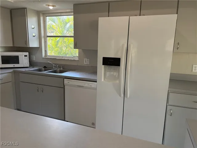 a kitchen with a sink a refrigerator a window and washer