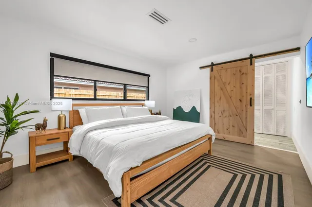 a bedroom with a bed and a large window