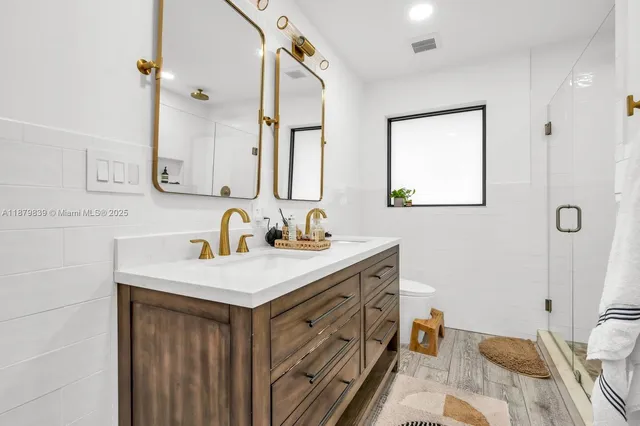 a bedroom with two beds a table and a potted plant next to a window