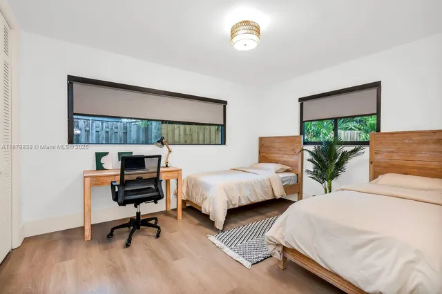 a bedroom with two beds and a window