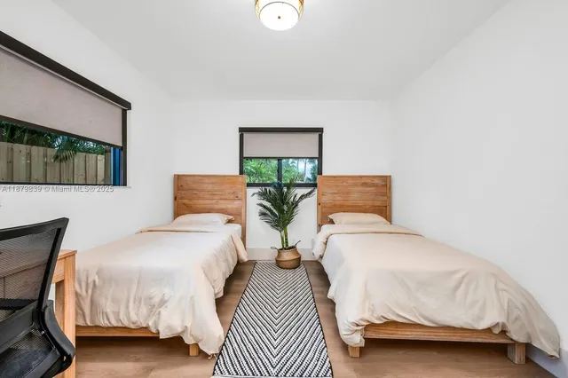 a bedroom with a bed and a potted plant