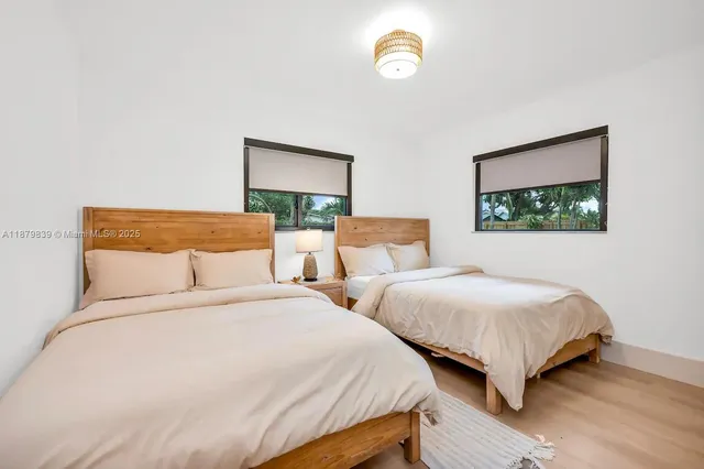 a bedroom with two beds and a potted plant