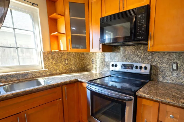 a kitchen with stainless steel appliances granite countertop a refrigerator stove and microwave