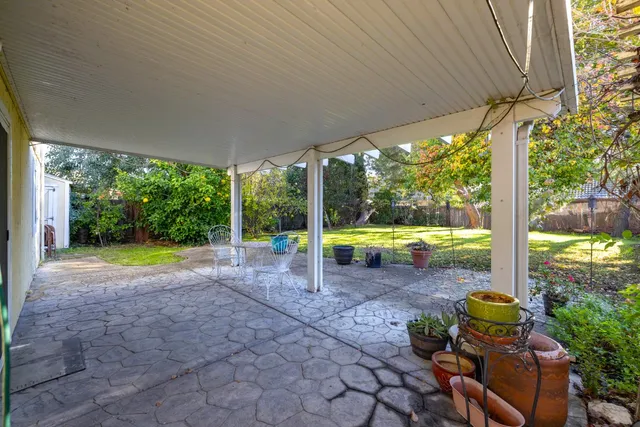 a view of a house with backyard and sitting area
